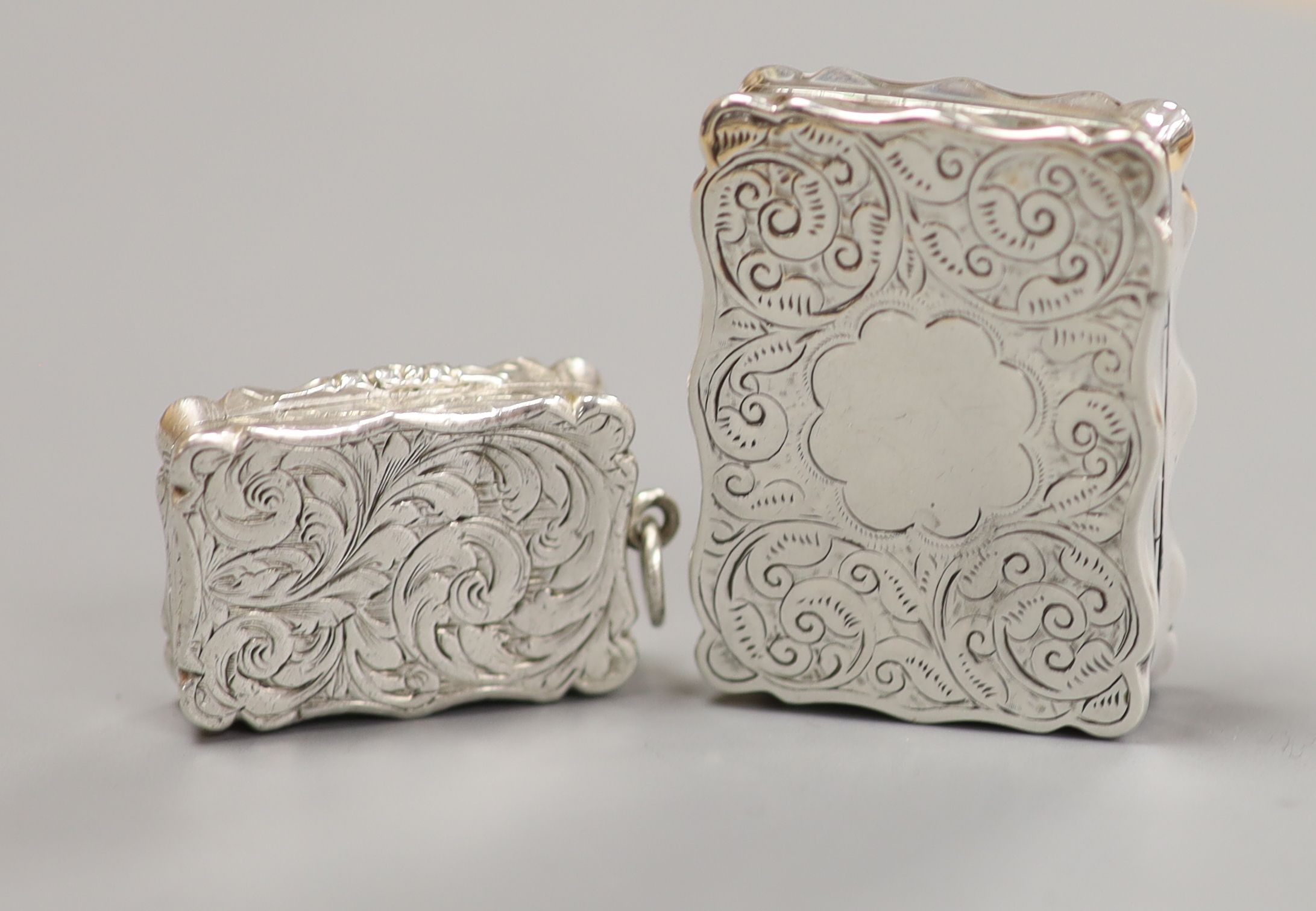 Two Victorian silver shaped rectangular vinaigrettes, Thomas Dones, Birmingham, 1855, 23mm and Colen Hewer Cheshire, Birmingham, 1895.